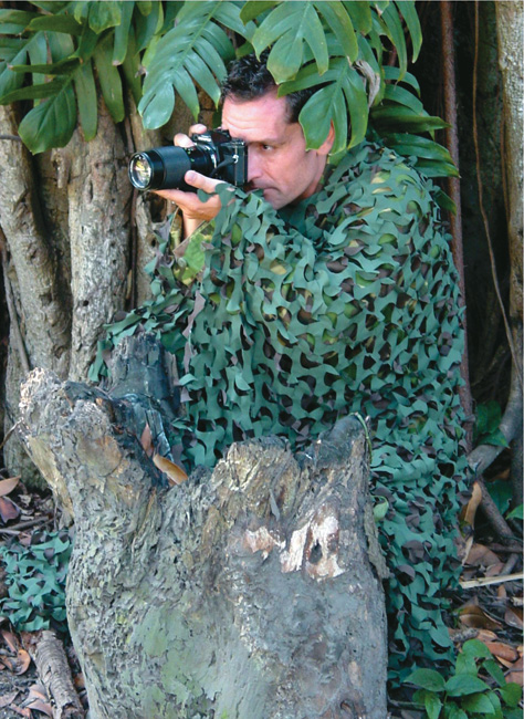 Fotograf v maskovací síti pro dokonalé maskování v přírodě